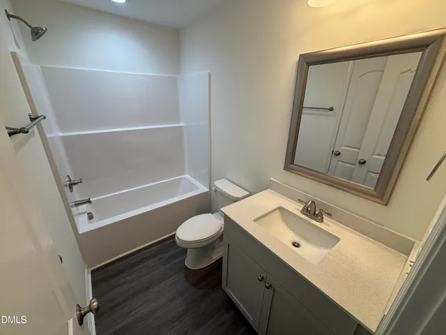 a bathroom with a sink mirror vanity and toilet