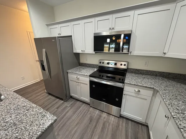 a kitchen with stainless steel appliances granite countertop a refrigerator stove and microwave