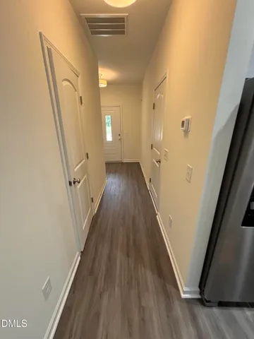 a view of a hallway with wooden floor and staircase