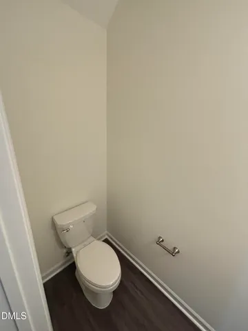 a white toilet sitting next to a white wall