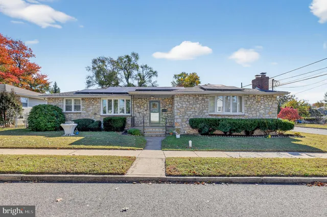 a view of a white house with a yard and plants