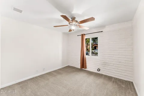 an empty room with closet and fan
