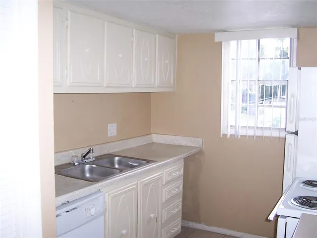 a kitchen with a sink cabinets and a window