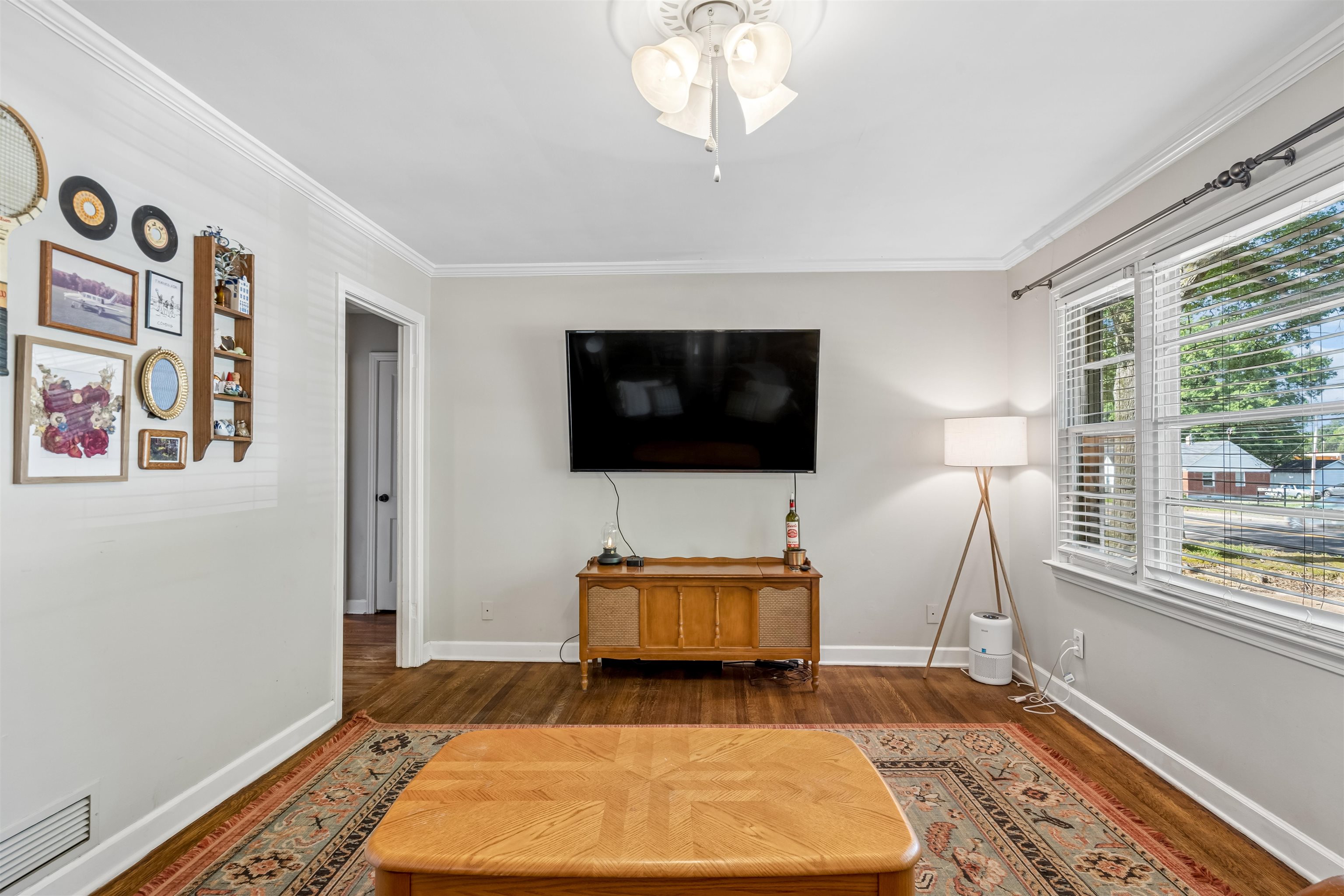 706 North Perkins Road Memphis, TN 38122 - Photo 6 of 20 Hardwood flooring, crown molding, white trim, multiple windows with blinds, and a ceiling fan with light fixture