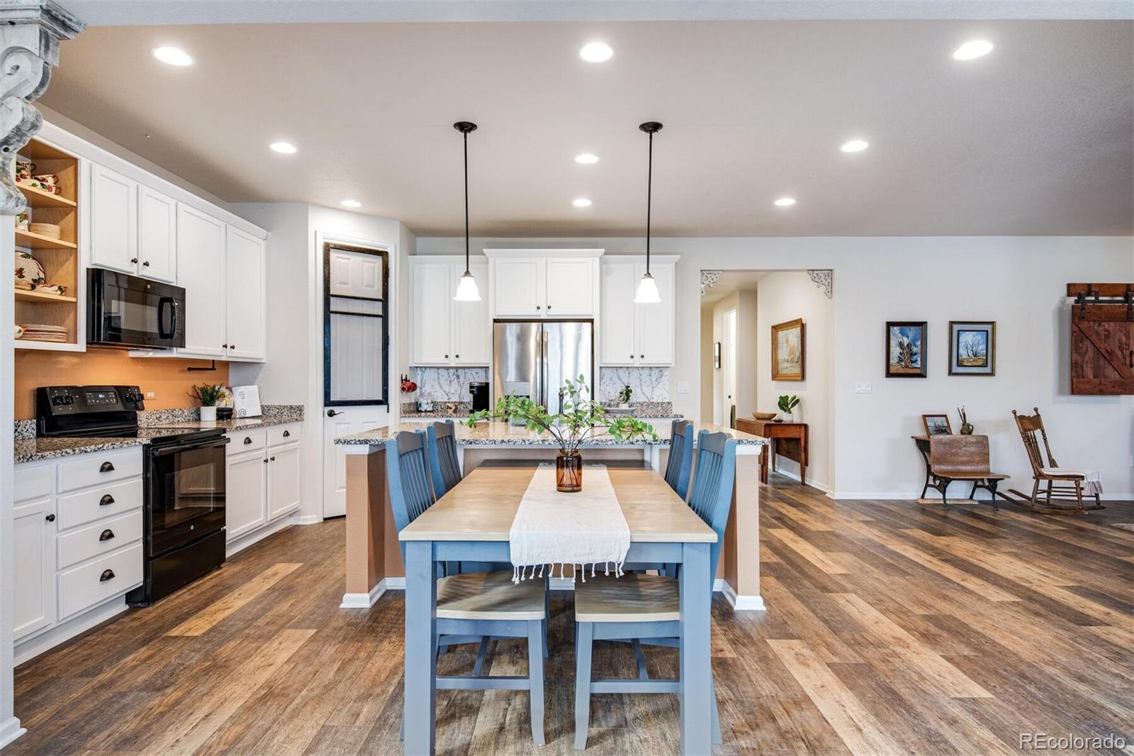 12646 Eagle River Road Firestone, CO 80504 - Photo 12 of 40 a dining room with stainless steel appliances kitchen island granite countertop a table chairs and a refrigerator