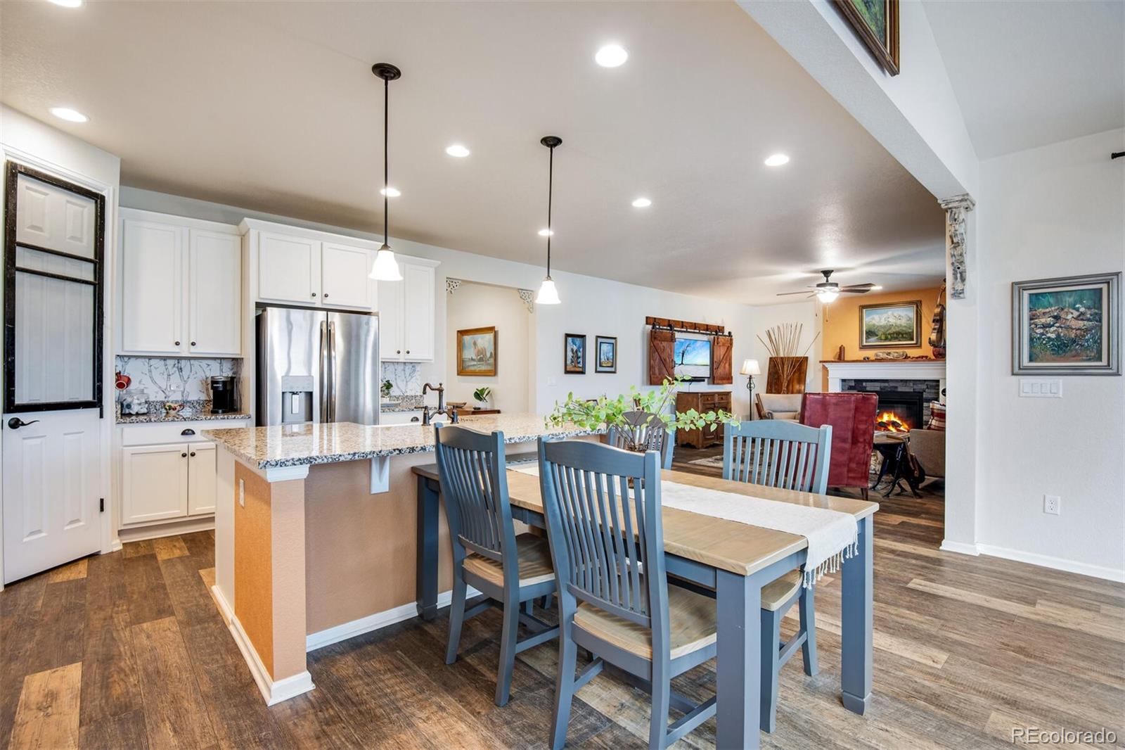 12646 Eagle River Road Firestone, CO 80504 - Photo 32 of 40 a dining room with stainless steel appliances kitchen island granite countertop a table chairs and a refrigerator