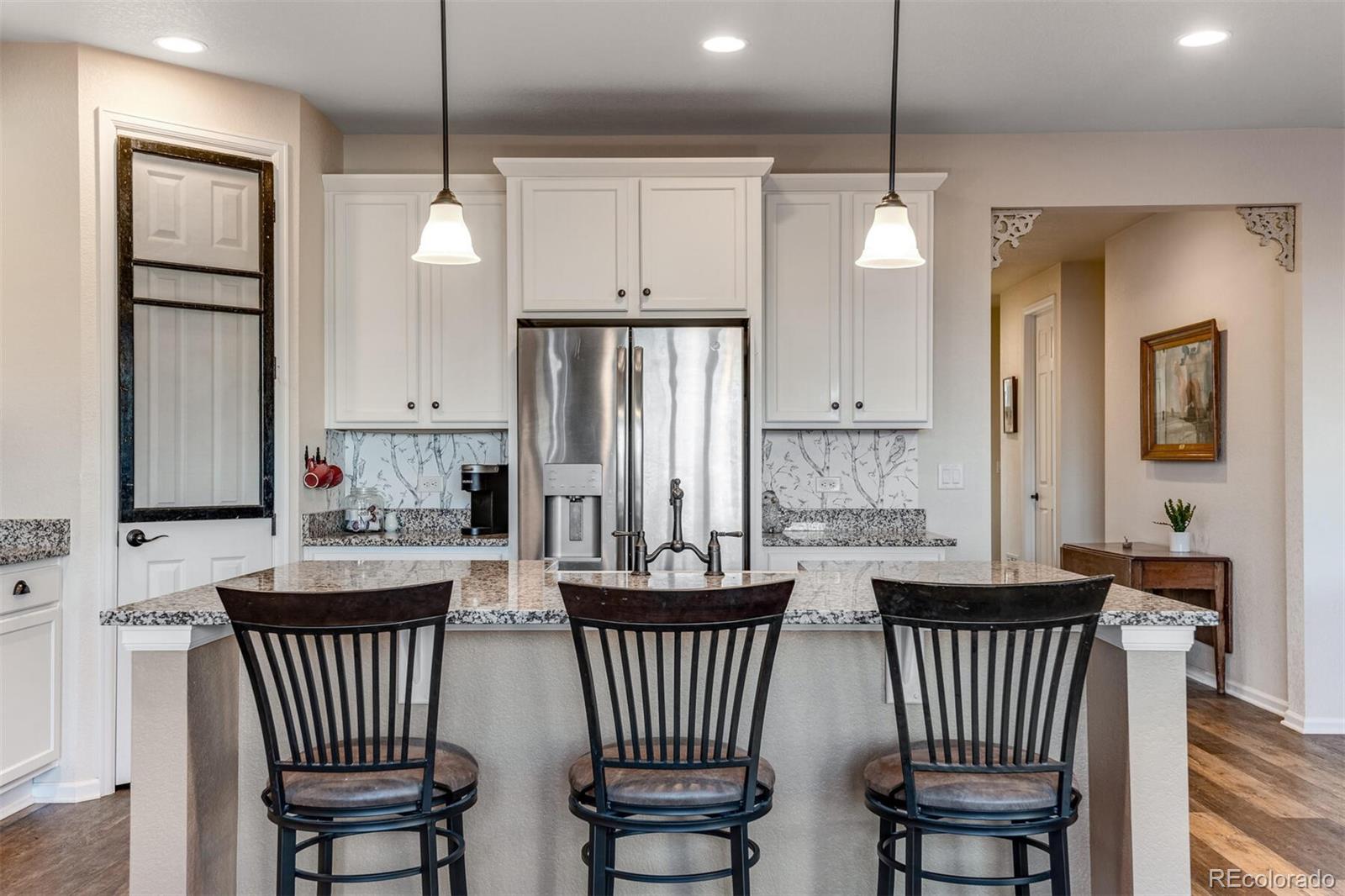 12646 Eagle River Road Firestone, CO 80504 - Photo 7 of 40 a kitchen with lots of white furniture and a chandelier