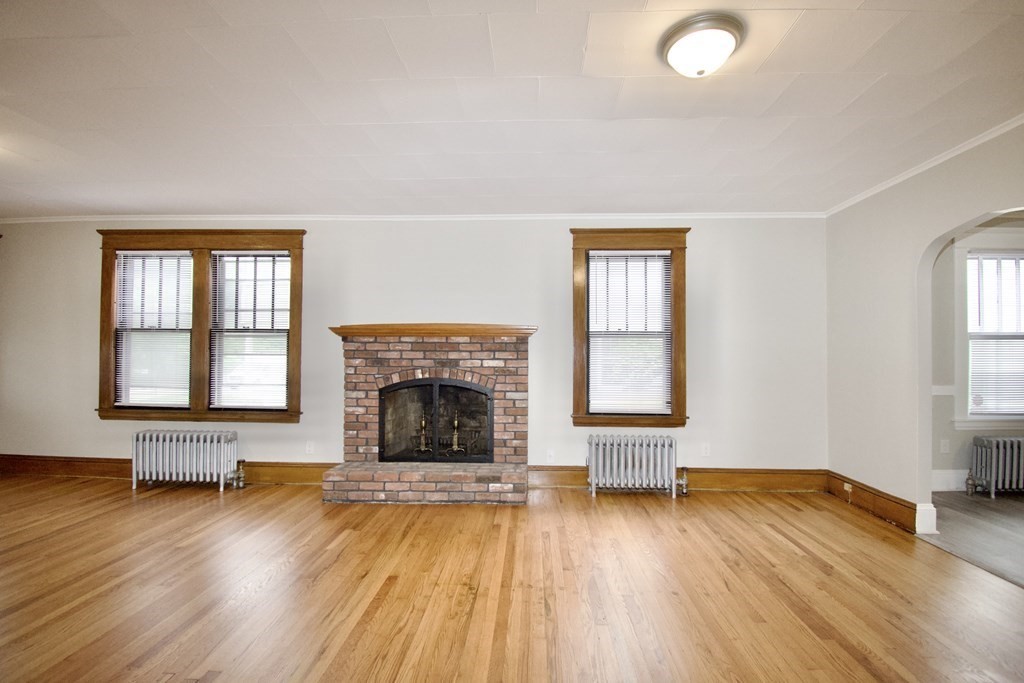 403-405 Main Street Springfield, MA 01151 - Photo 4 of 27 an empty room with fireplace wooden floor and windows