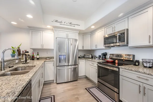 a kitchen with kitchen island granite countertop a sink stainless steel appliances and cabinets