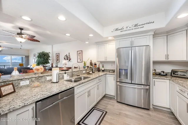 a kitchen with granite countertop a refrigerator stove top oven and sink