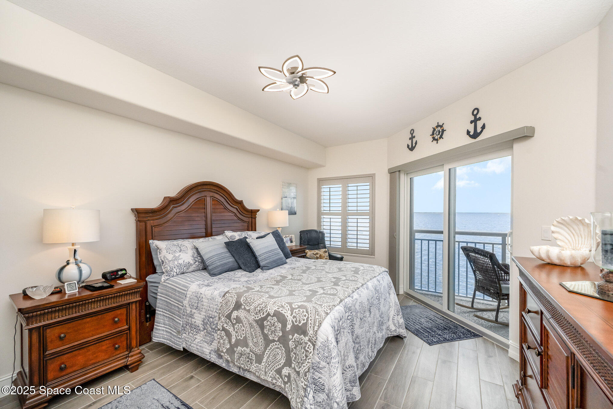 1825 Riverside Drive, Unit 202 Titusville, FL 32780 - Photo 18 of 31 a bedroom with a bed and a chandelier