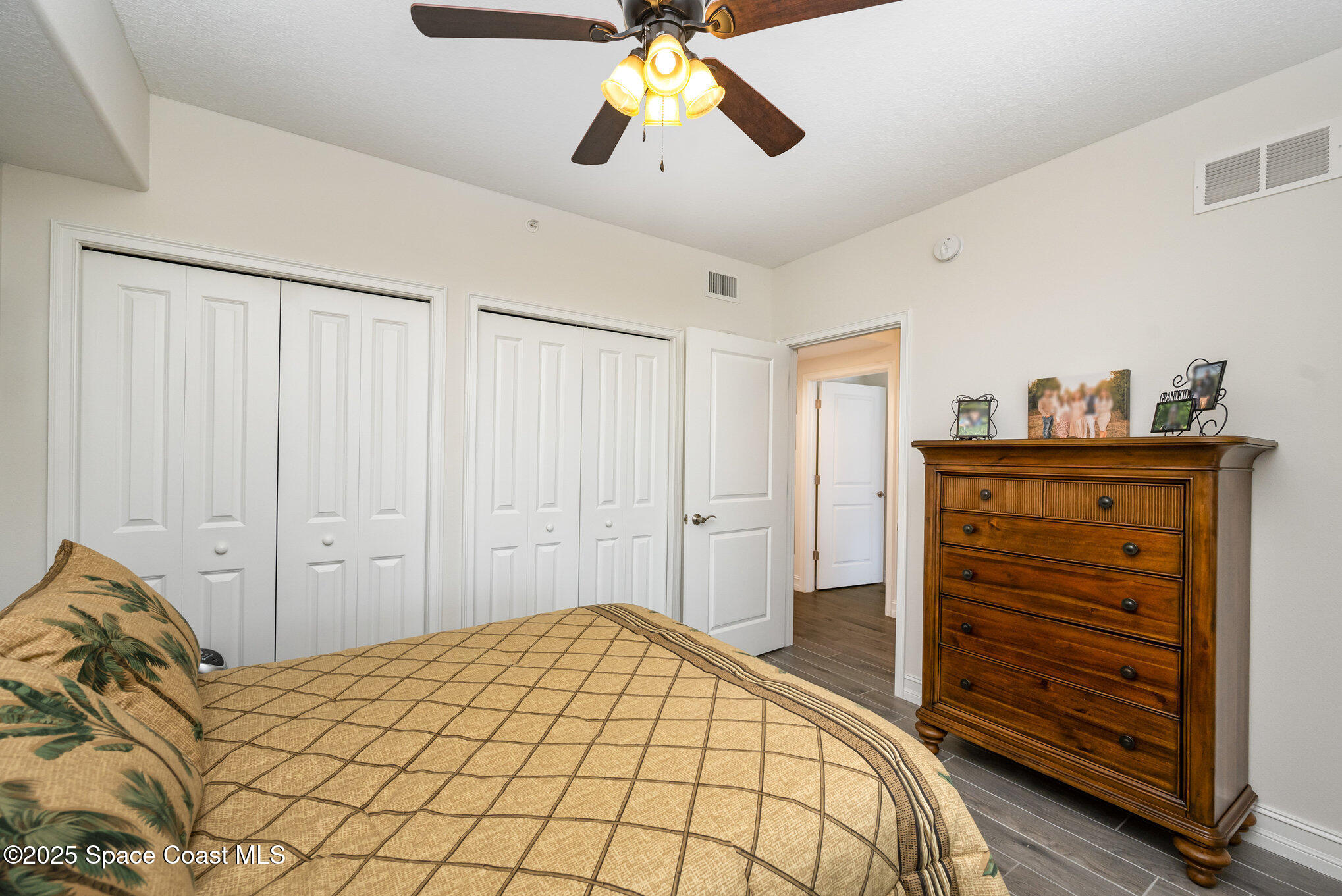 1825 Riverside Drive, Unit 202 Titusville, FL 32780 - Photo 22 of 31 a bedroom with a bed and a chandelier