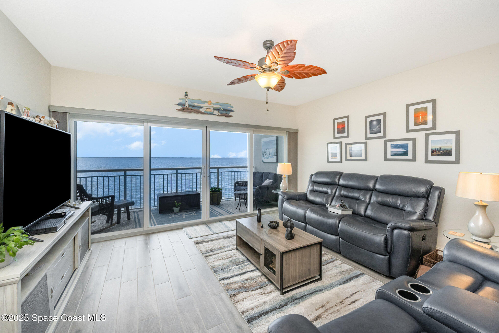 1825 Riverside Drive, Unit 202 Titusville, FL 32780 - Photo 9 of 31 a living room with furniture a fireplace and a flat screen tv