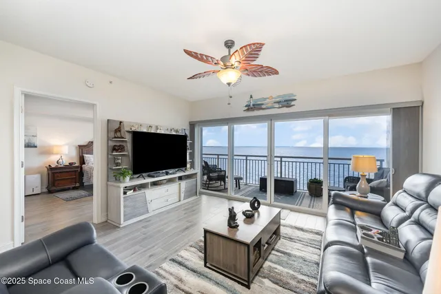 a living room with furniture a large window and a flat screen tv