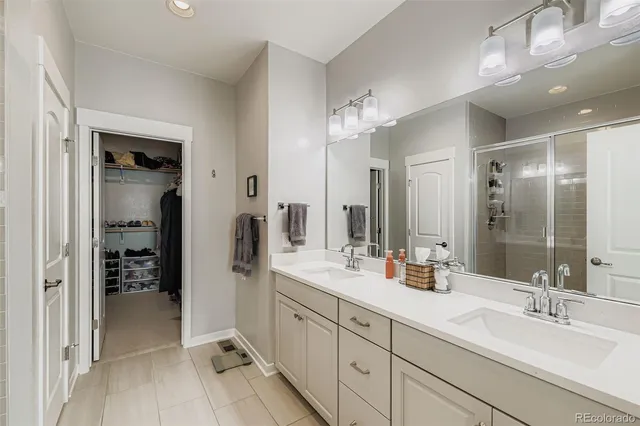 a spacious bathroom with a double vanity sink mirror and shower