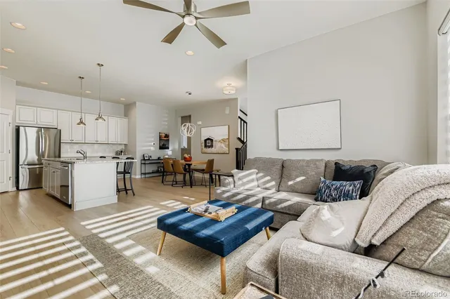 a living room with furniture kitchen view and a refrigerator