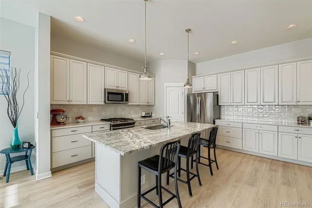 a kitchen with stainless steel appliances granite countertop a stove refrigerator sink and cabinets