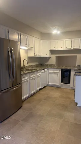 a kitchen with stainless steel appliances granite countertop a refrigerator a sink a stove and oven with wooden floor