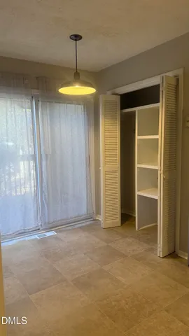a view of empty room with a window and ceiling fan