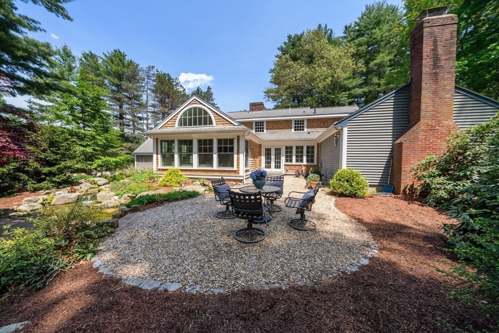 49 Walpole Street Dover, MA 02030 - Photo 31 of 40 a front view of a house with a garden and sitting area