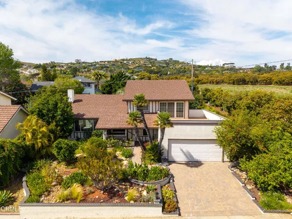 an aerial view of a house with a garden and lake view