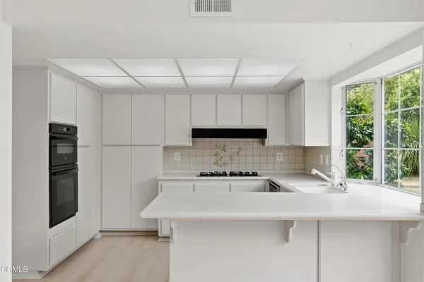 a kitchen with a sink a refrigerator and a stove top oven
