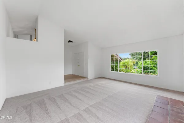 an empty room with windows and a fireplace