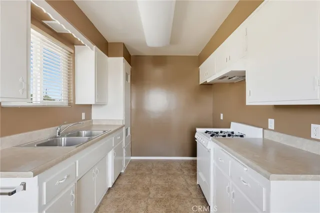 a kitchen with a sink stove and cabinets