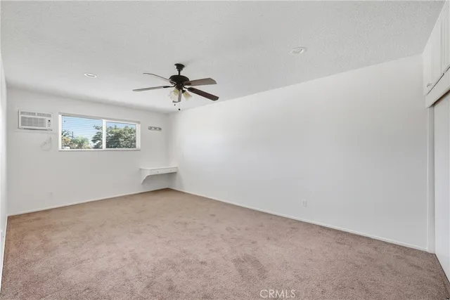 an empty room with a window and a ceiling fan