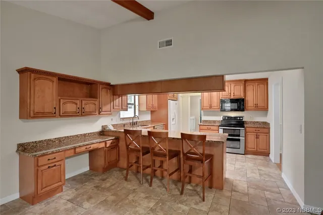 a kitchen with stainless steel appliances granite countertop a stove top oven a sink dishwasher and a microwave oven on the blue kitchen countertops