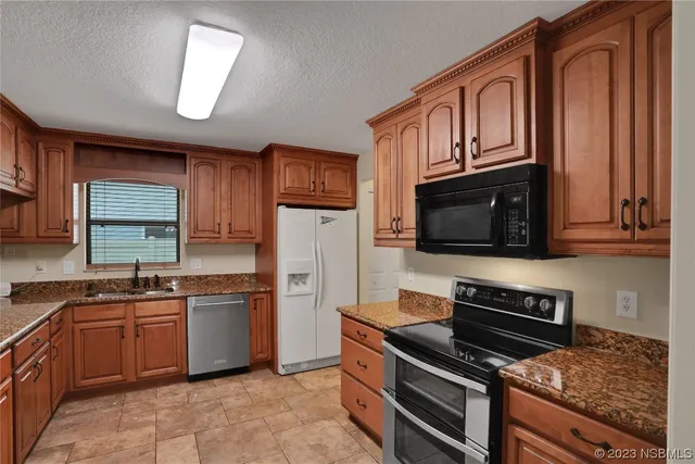 a kitchen with granite countertop a sink and cabinets