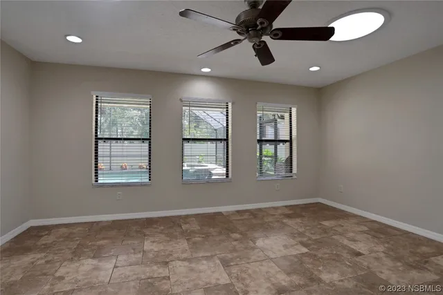 an empty room with a window and a fan