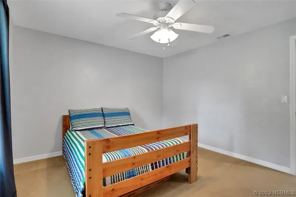 an empty room with a window and a ceiling fan