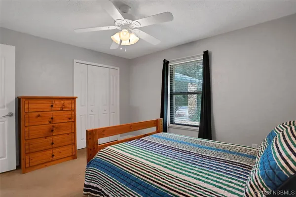 an empty room with a ceiling fan and a bathroom