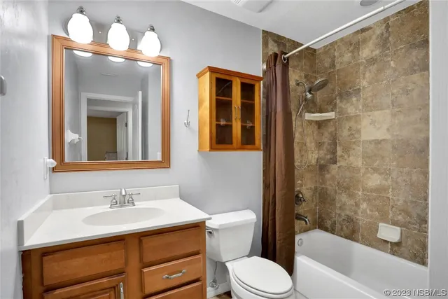 an empty room with a chandelier fan and windows