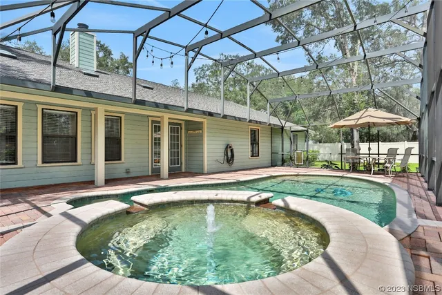 an aerial view of residential house with outdoor space and trees all around