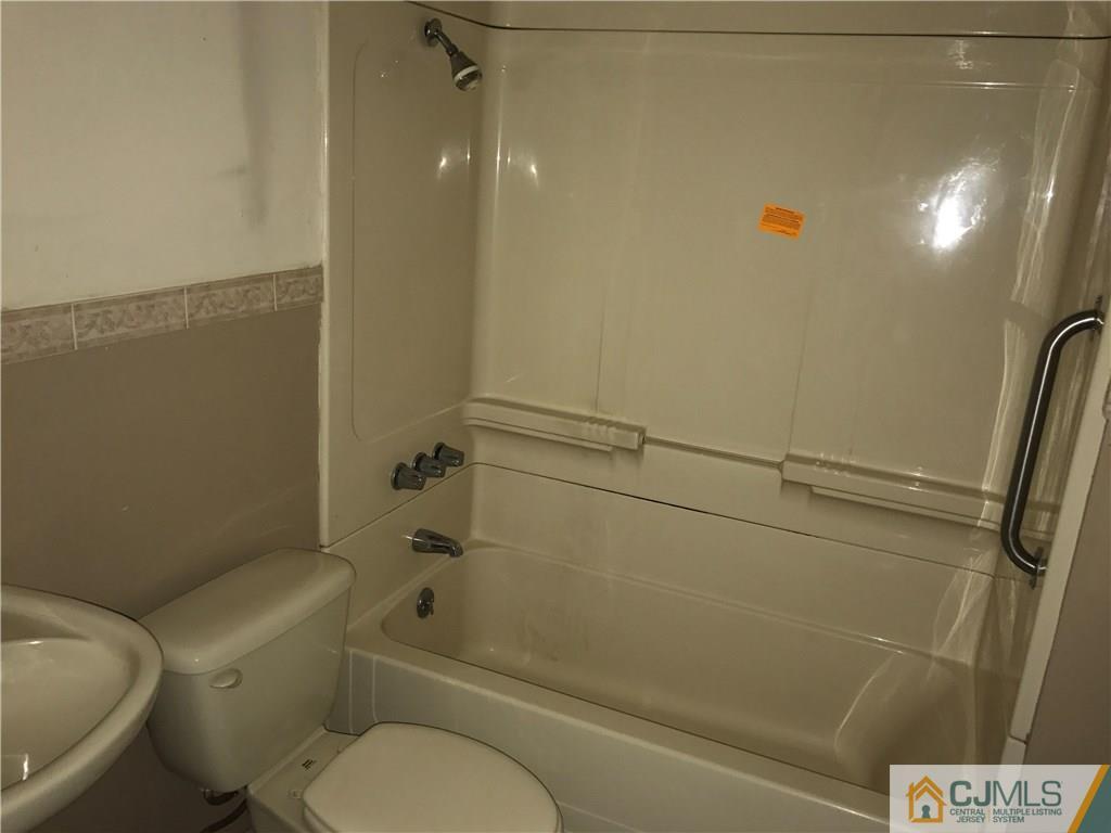 47 Kenmore Road Edison, NJ 08817 - Photo 11 of 14 a white toilet sitting next to a bath tub