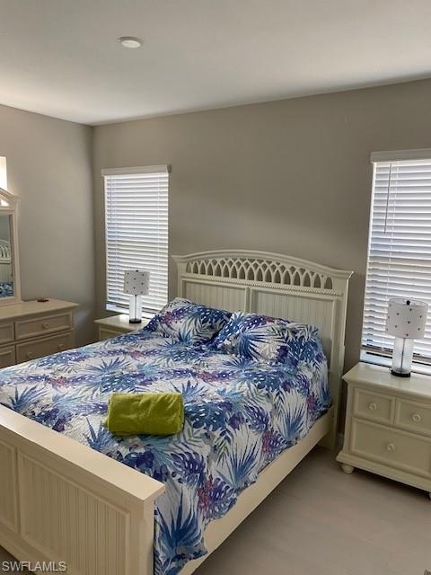 1330 Oceania Drive, Unit 2 Naples, FL 34113 - Photo 14 of 30 a bedroom with a bed and a dresser