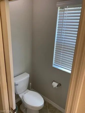 a white toilet sitting next to a window