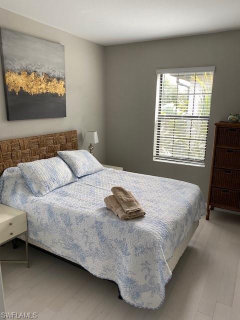 1330 Oceania Drive, Unit 2 Naples, FL 34113 - Photo 24 of 30 a bedroom with a bed and a flat screen tv