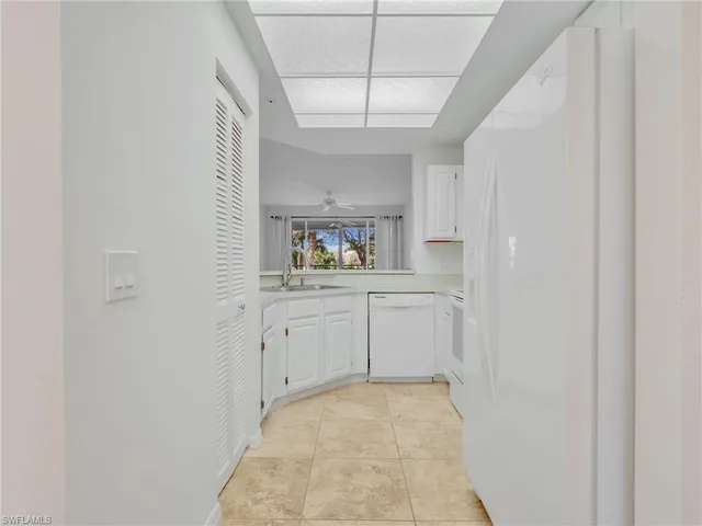 a kitchen with white cabinets appliances and a sink