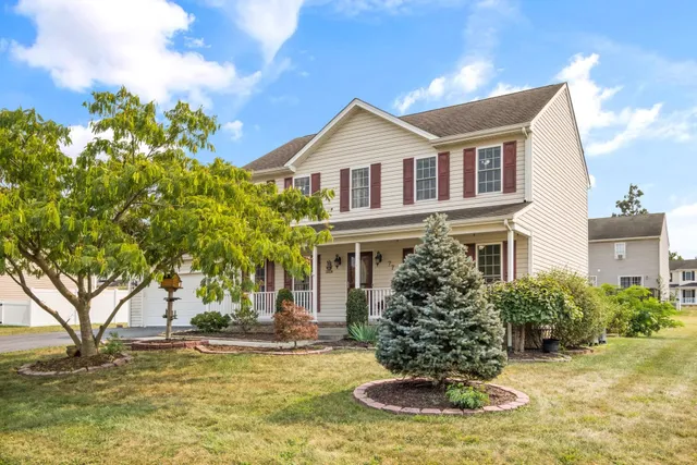 a front view of a house with a yard garage and outdoor seating