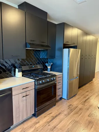 a kitchen with stainless steel appliances granite countertop a stove a refrigerator and a microwave