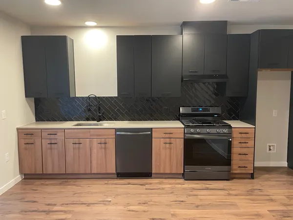 a kitchen with stainless steel appliances granite countertop a stove a sink and a refrigerator