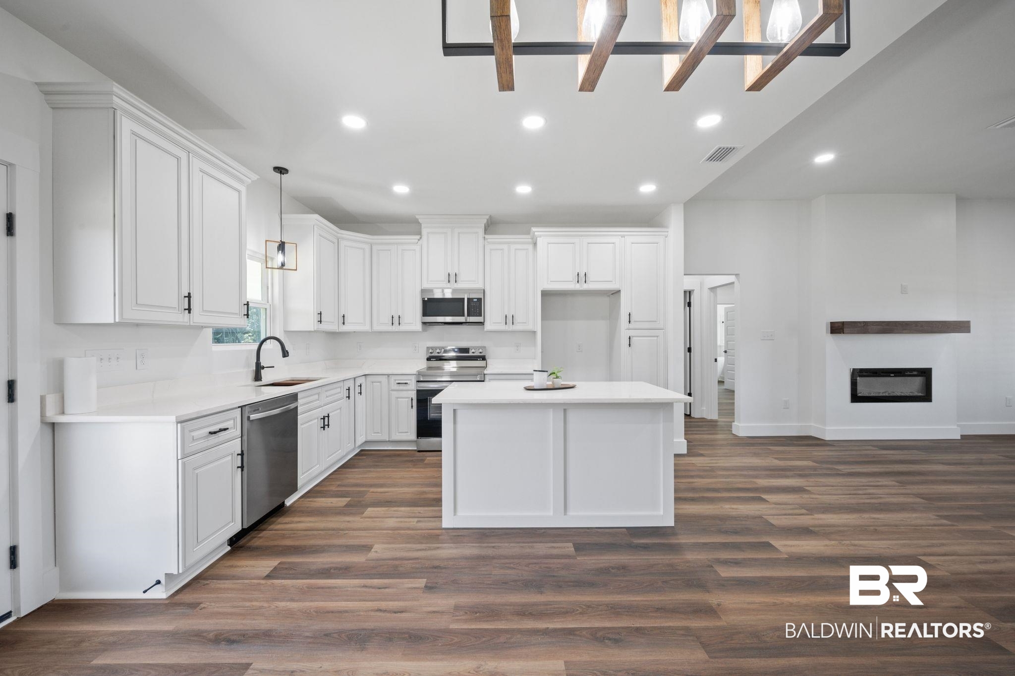 12100 Lott Road Chunchula, AL 36521 - Photo 5 of 21 Kitchen featuring hardwood / wood-style flooring, hanging light fixtures, sink, a center island, and appliances with stainless steel finishes