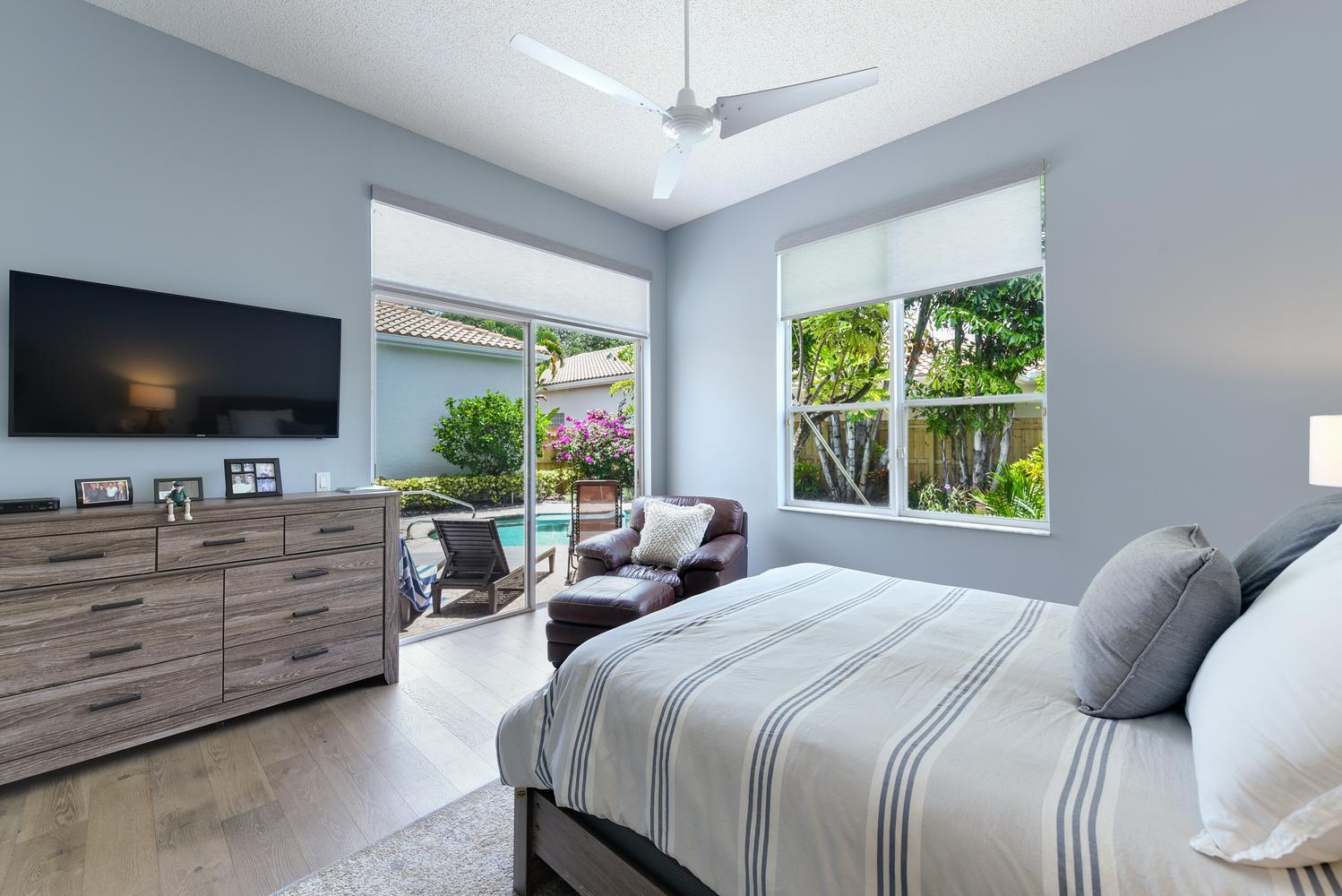 6685 Northwest 24th Terrace Boca Raton, FL 33496 - Photo 13 of 31 a bedroom with a large bed and a flat screen tv