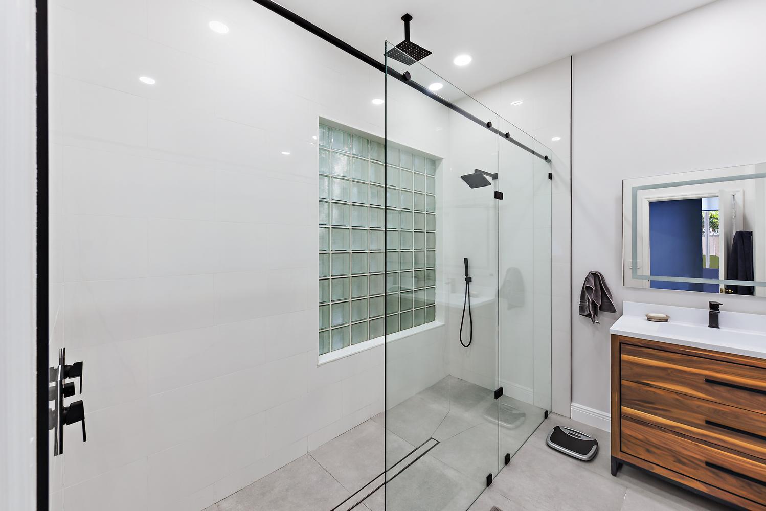 6685 Northwest 24th Terrace Boca Raton, FL 33496 - Photo 15 of 31 a bathroom with a double vanity sink a mirror and a shower