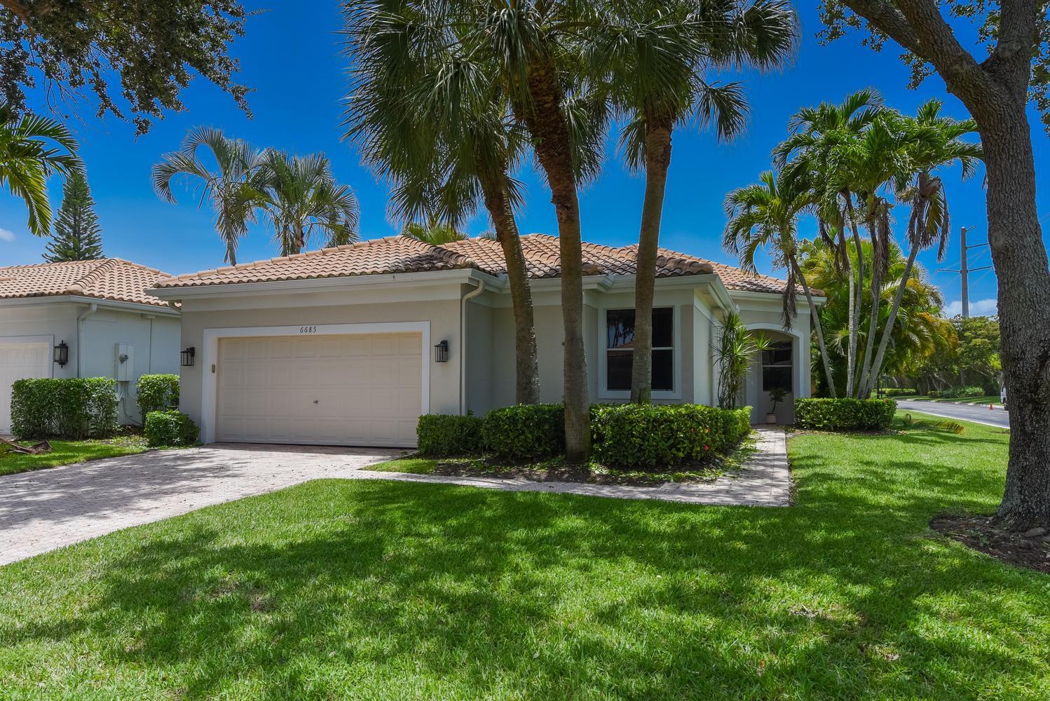 6685 Northwest 24th Terrace Boca Raton, FL 33496 - Photo 2 of 31 a view of a white house next to a yard with palm trees