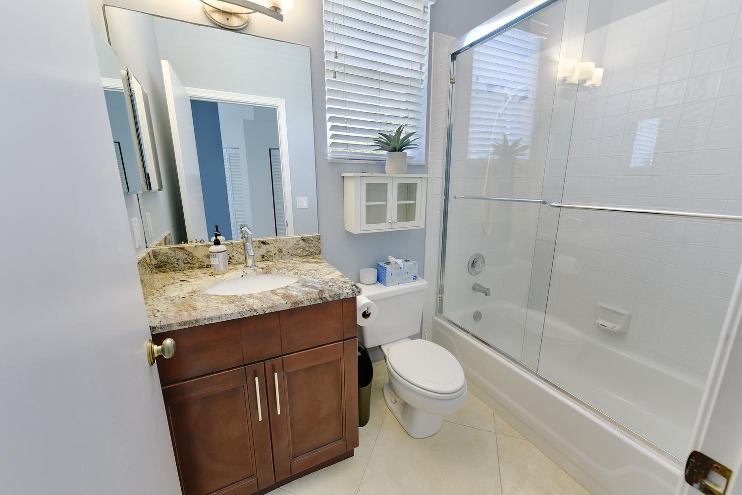 6685 Northwest 24th Terrace Boca Raton, FL 33496 - Photo 21 of 31 a bathroom with a granite countertop sink toilet and shower
