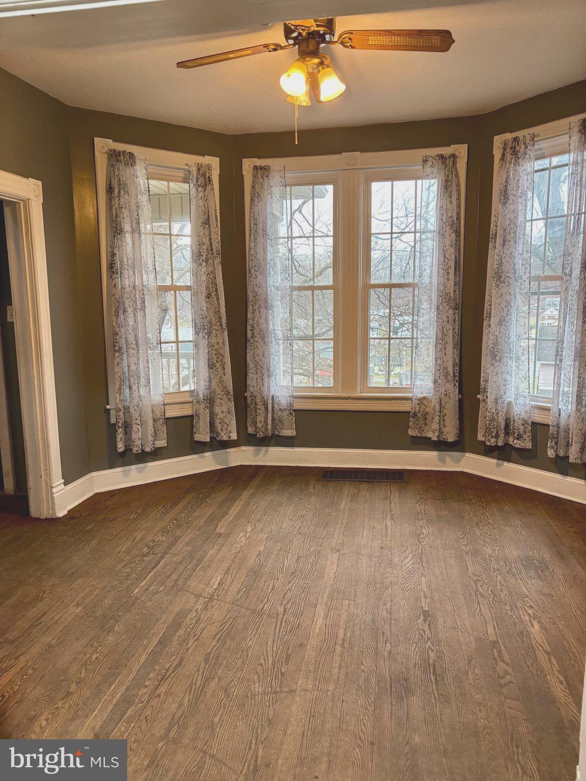 1006 Main Street Saxton, PA 16678 - Photo 17 of 40 a view of an empty room with wooden floor and a window
